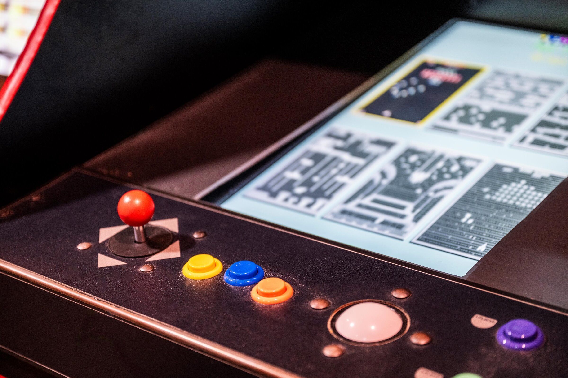A video game arcade machine with a joystick and colorful buttons.