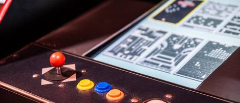 A video game arcade machine with a joystick and colorful buttons.