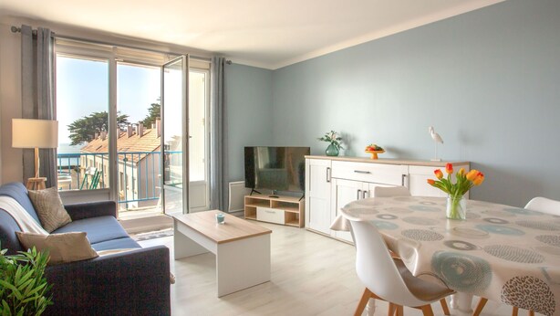 A modern apartment with a balcony, a dining area, and a living room.