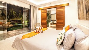 Un dormitorio moderno con una cama grande, un vidrio que da a una piscina y un armario de madera.