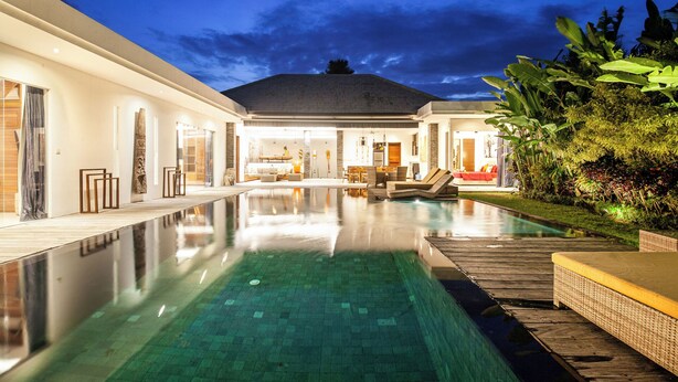 Una casa moderna con piscina, comedor y sala de estar.