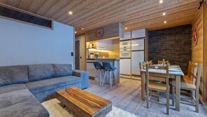 A modern living room with a sofa, coffee table, and dining area with chairs and a table. - 40m from ski slopes, 2nd floor, fitness, swimming pool, sauna, tv, ski locker, 56m², Les Orres (Les Orres)