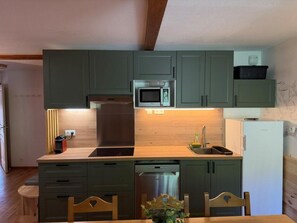 A compact kitchen with a microwave, sink, and dishwasher.