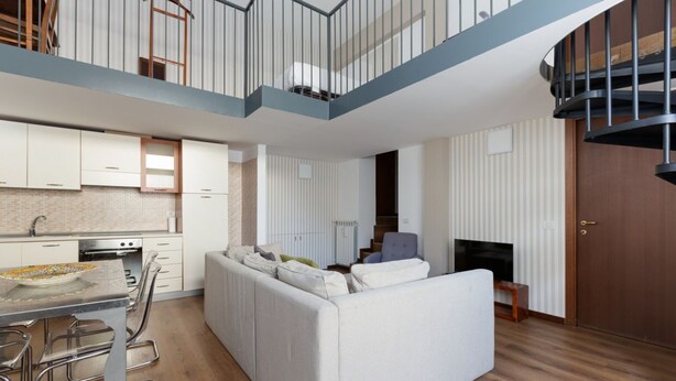 Un apartamento moderno con cocina, comedor, sala de estar y una escalera.