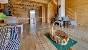 Ein Holzinnenraum mit Küche, Essbereich und Kamin.