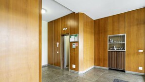 A hallway with wooden paneling, a reception area, and a glass display case. - GuestHost - Modern Santa Rita Apartment - Padova (Padova)