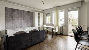A modern room with a bed, a dining table, and chairs. - GuestHost - Modern Santa Rita Apartment - Padova (Padova)