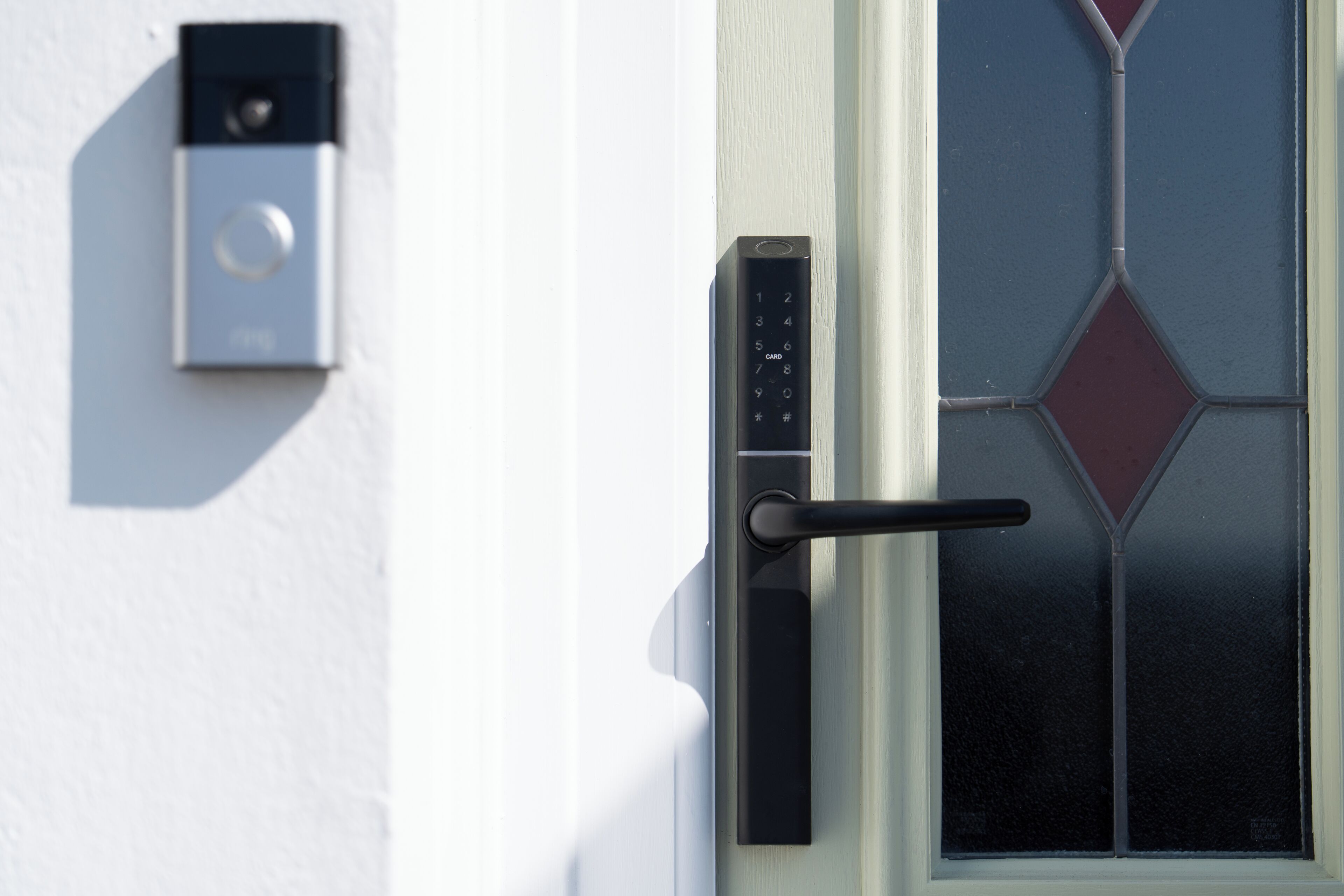 A door with a keypad lock and a card reader installed on the wall beside it.