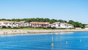 A coastal hotel with multiple-story buildings, a sandy beach, and a clear blue sea. - Les Pêcheurs by Interhome (Mimizan)