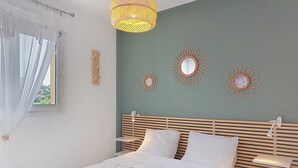 A neatly made bed with white linens, a wooden headboard, and bedside tables with lamps. - Les Pêcheurs by Interhome (Mimizan)