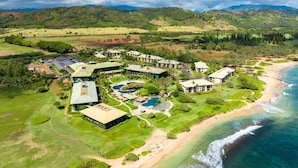 Et resort med flere bygninger, et stort poolområde og en strand.