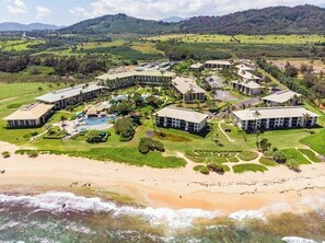 Ein Resort mit mehreren Gebäuden, einem Schwimmbad und einem Strand.
