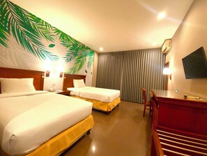 A hotel room with two beds, a desk, a chair, a TV, and a large window with curtains. - HOTEL GOLDEN SEASON (Samarinda)