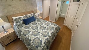 A bedroom with a bed, a nightstand, a ceiling fan, a window with blinds, a door leading to a bathroom, and a wardrobe. - Clean Penthouse with Balcony (Burbank)