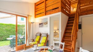 Un coin repas accueillant, avec une table mise pour le petit-déjeuner, des chaises en bois et un escalier menant à l’étage supérieur.