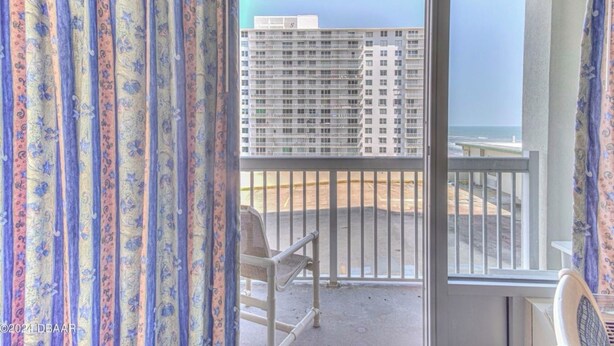 A balcony with a view of a high-rise building and a beach. - Ocean View Charming condo at Daytona Beach (Daytona Beach)