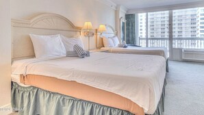 A hotel room with two beds, a large window with a city view, and a balcony. - Ocean View Charming condo at Daytona Beach (Daytona Beach)