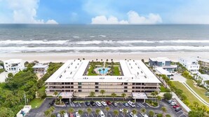 A multi-story hotel with a central courtyard, parking lot, and ocean view. - Pelican View 3 Bedroom Ocean House 308 (Saint Augsutine)