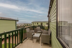 A balcony with wicker furniture and a view of other similar buildings.