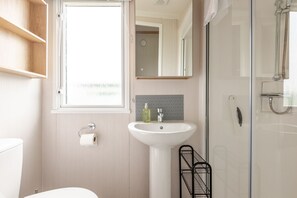 A bathroom with a toilet, sink, and shower.