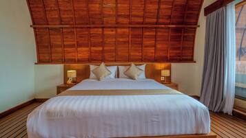 A large bed with a wooden headboard, two bedside lamps, and a view of the outdoors through a window with curtains.