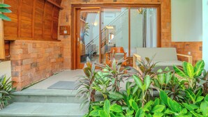 A brick exterior with a wooden door and steps leading to a covered entrance. - Villa Radha Pererenan (Pererenan)