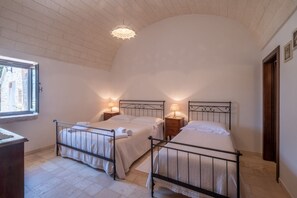 Una camera da letto con due letti, una finestra e un lampadario.
