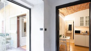 A modern kitchen with white cabinets, a wooden countertop, and a microwave.