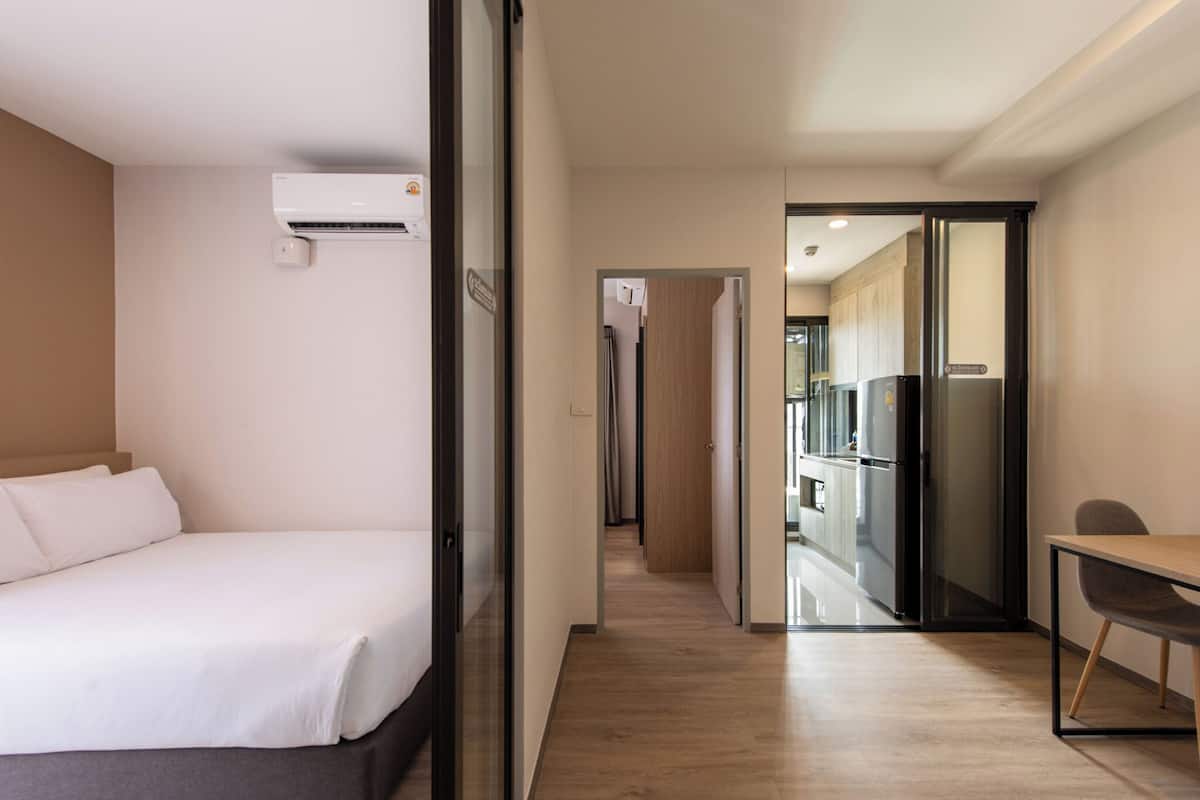 Ein Hotelzimmer mit Bett, Schreibtisch und einer Küchenzeile.