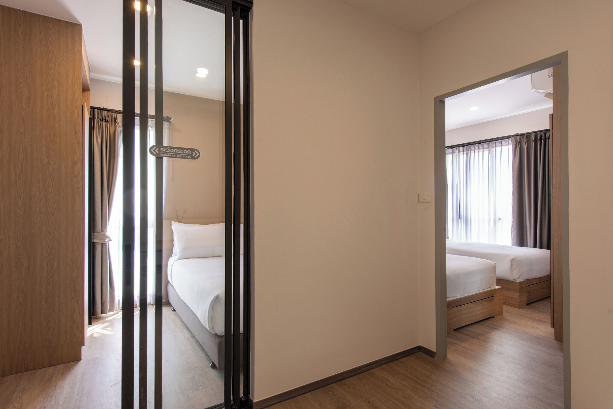 Habitación de hotel con una cama, una puerta de madera y vista a otra habitación.