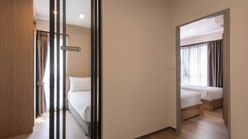 Habitación de hotel con una cama, una puerta de madera y vista a otra habitación.