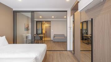 Una habitación de hotel moderna con una cama grande, un escritorio y una zona de estar.