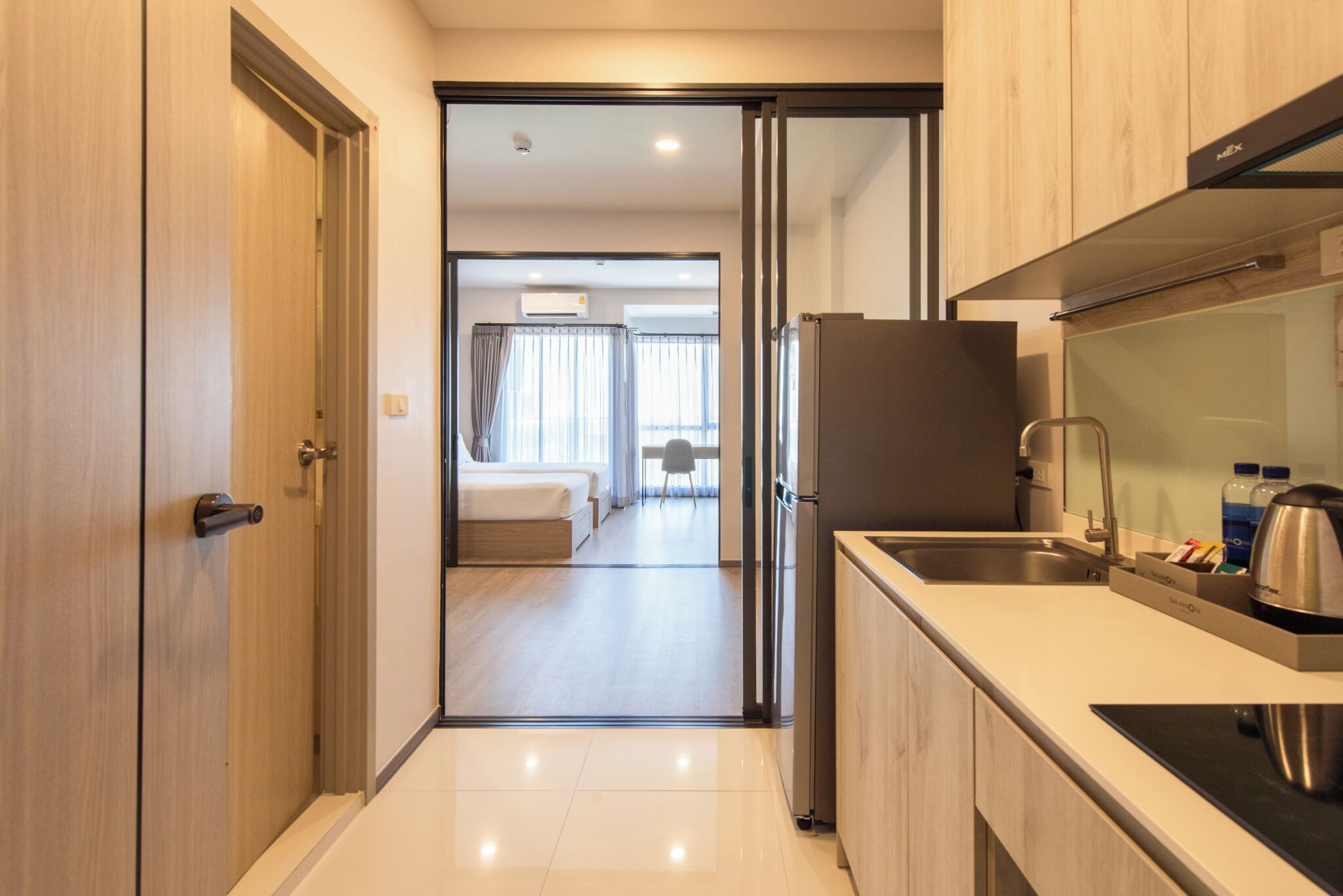 A modern kitchen with a refrigerator, sink, and countertop.