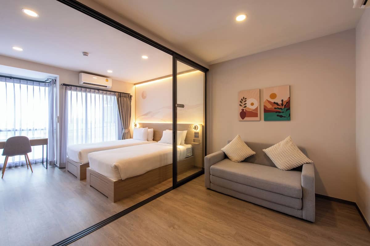 Ein Hotelzimmer mit einem Bett, einem Sofa, einem Schreibtisch und einem Sessel.