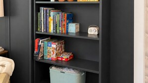 Ein Bücherregal mit Büchern, einem Radio und Aufbewahrungsboxen.