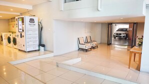 Een moderne hotel lobby met een drankautomaat, een zithoek en een inrit voor auto's.