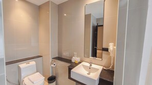 Une salle de bain moderne avec des toilettes, un lavabo et un miroir.