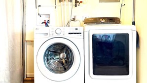 A front-loading washer and dryer in a laundry room with visible plumbing and a Samsung dryer control panel. - Emerald - GREAT PARK, 3br, Yard, Pet-Friendly (Paulding)