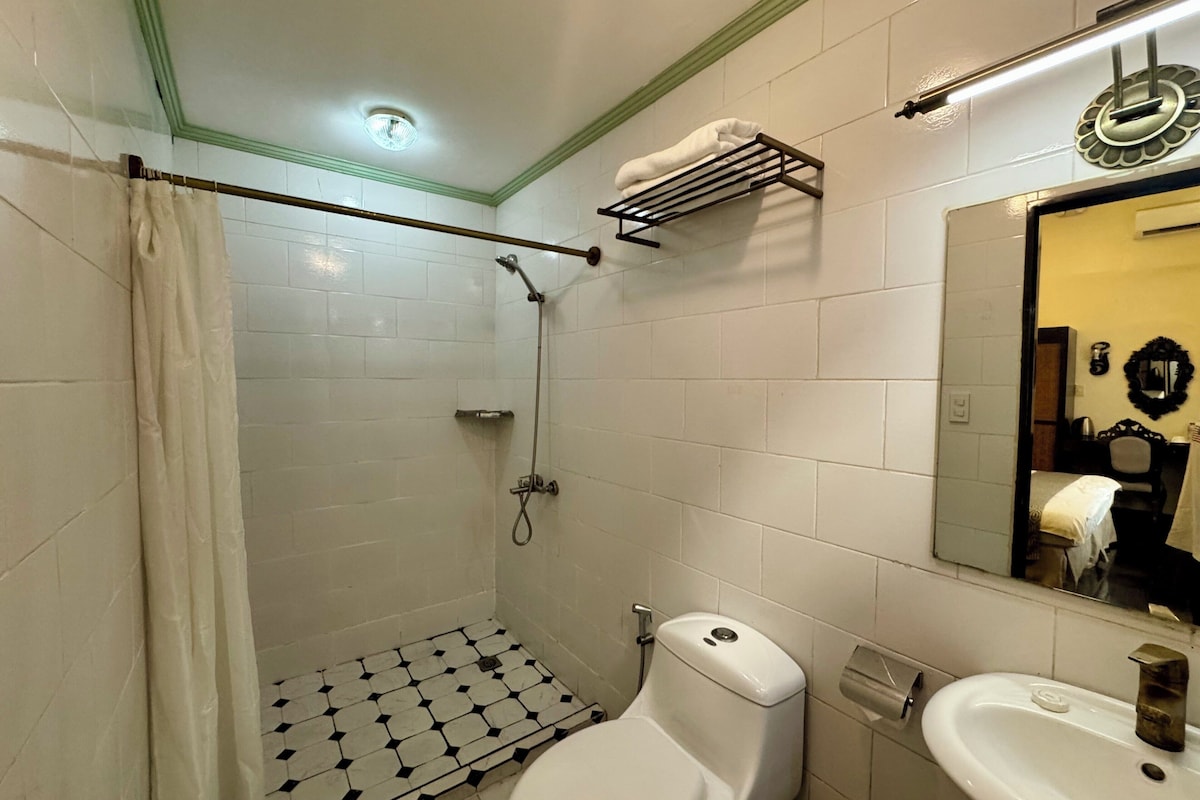 Une salle de bain équipée d’une douche, de toilettes, d’un lavabo et d’un miroir.