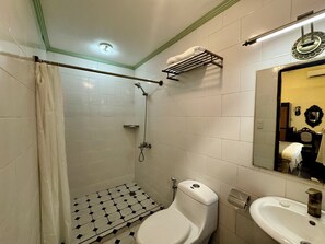 A bathroom with a shower, toilet, sink, and a mirror. - Park Avenue Boutique Hotel (Pasay)