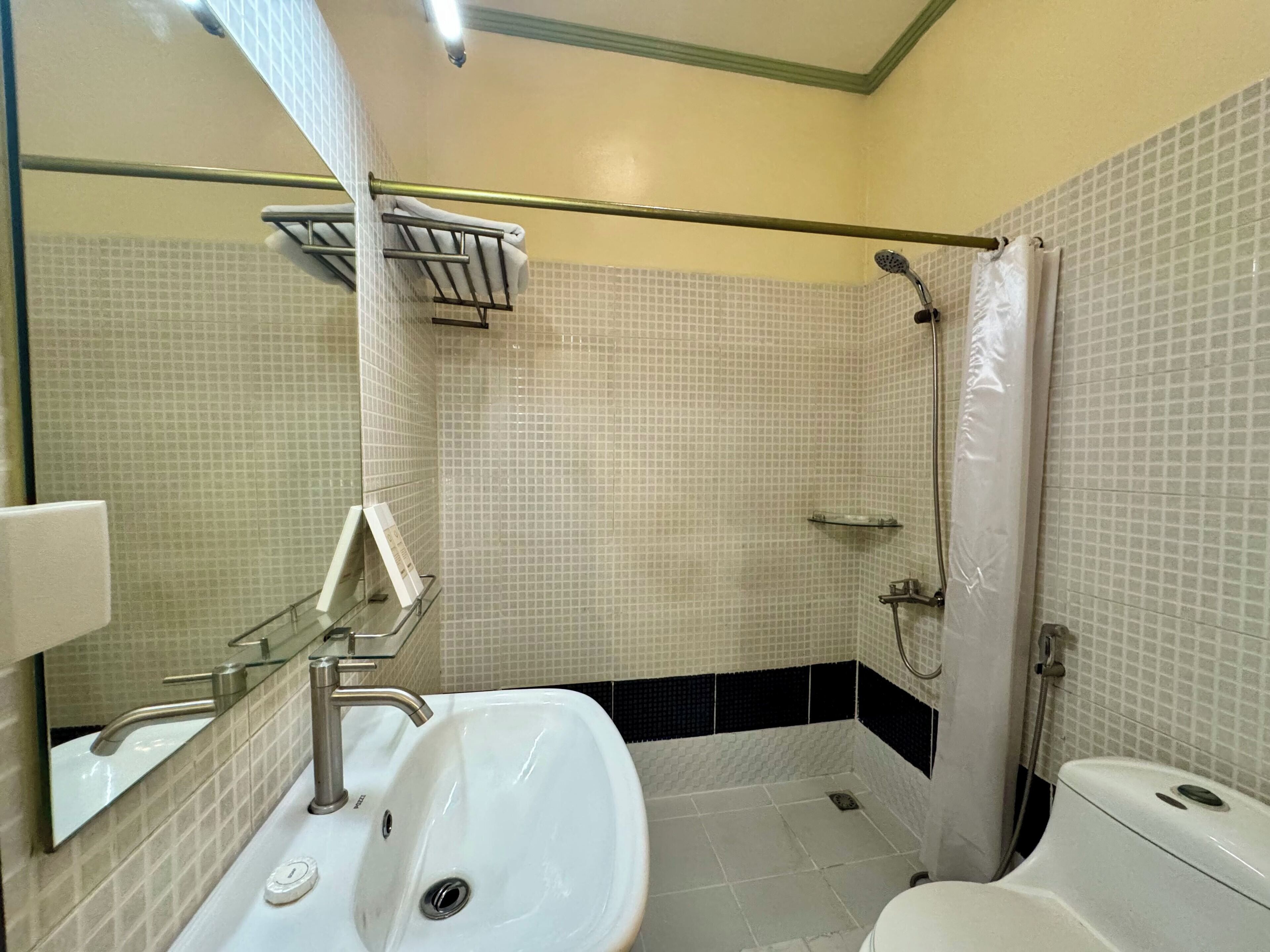 Un baño con lavamanos blanco, inodoro y zona de ducha.