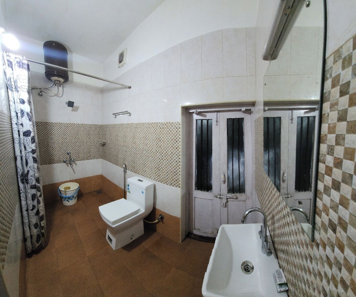 A bathroom with a toilet, sink, and shower area.