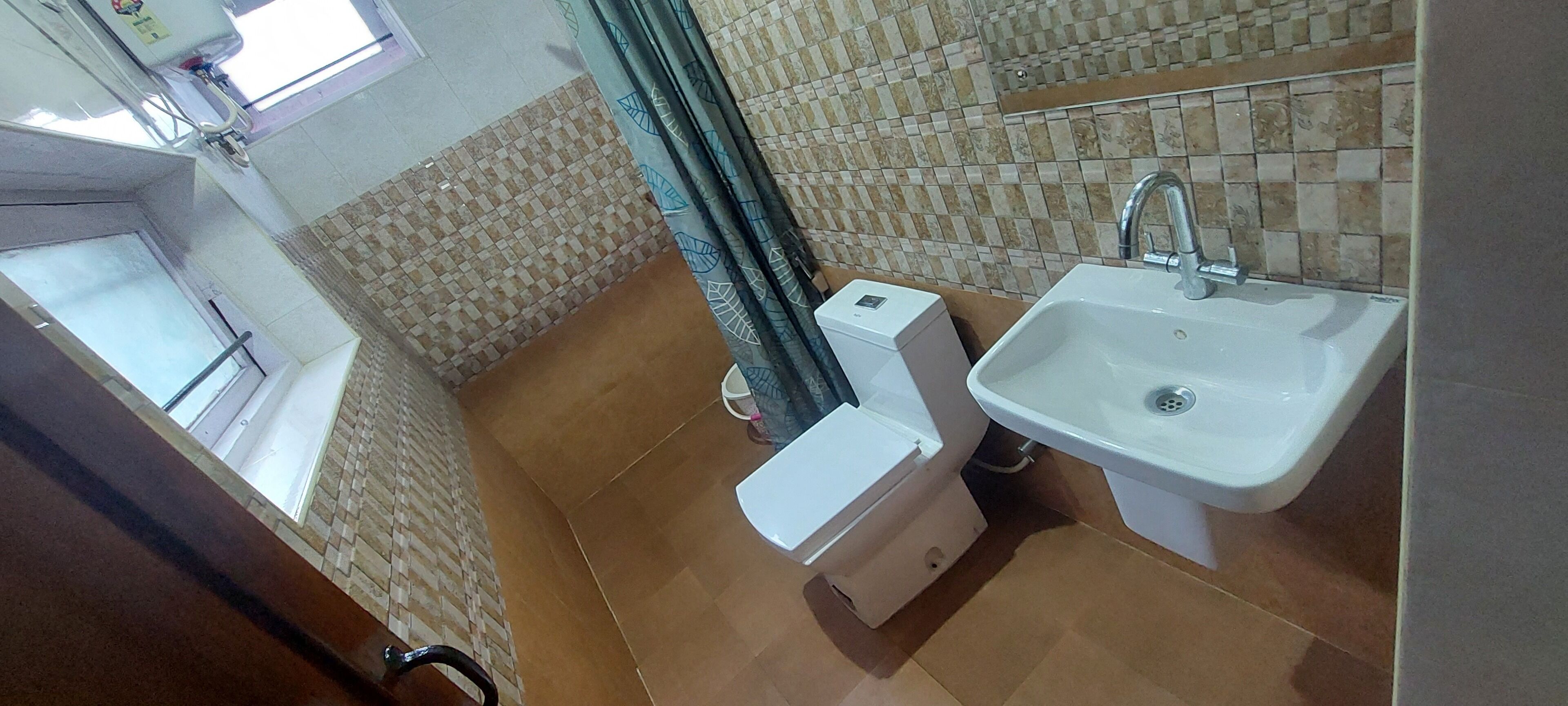 Un baño con inodoro, lavamanos y paredes de azulejos.