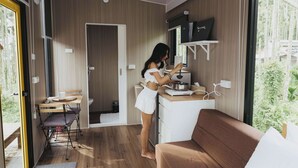 Una cocina compacta con comedor, sofá y vistas a zonas verdes.