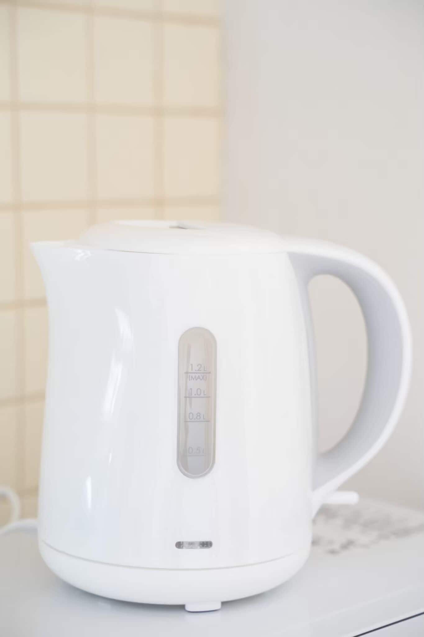 A white electric kettle with measurement markings on the side.