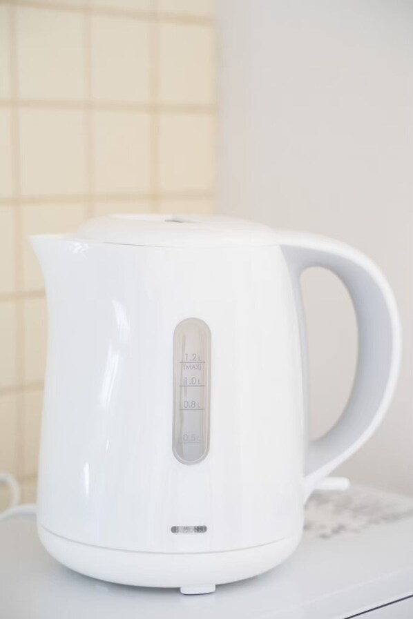 A white electric kettle with measurement markings on the side. - Living CUBE Beppu Station Annex (Beppu)