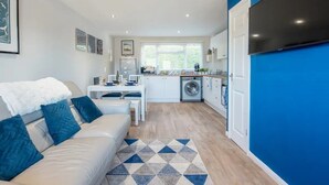 A modern apartment with a living area, kitchen, and laundry facilities. - Sea View Chalet | Walk to Freshwater Beach (Pembrokeshire)
