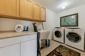 A laundry area with a washing machine, dryer, and Tide detergent.