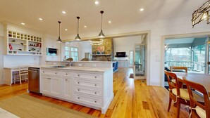 A spacious kitchen with a central island, wooden flooring, and pendant lighting. - Luxury Home. Blue Valley Views. Extraordinary Attention to Detail | Sevenoaks Cottage (Highlands)