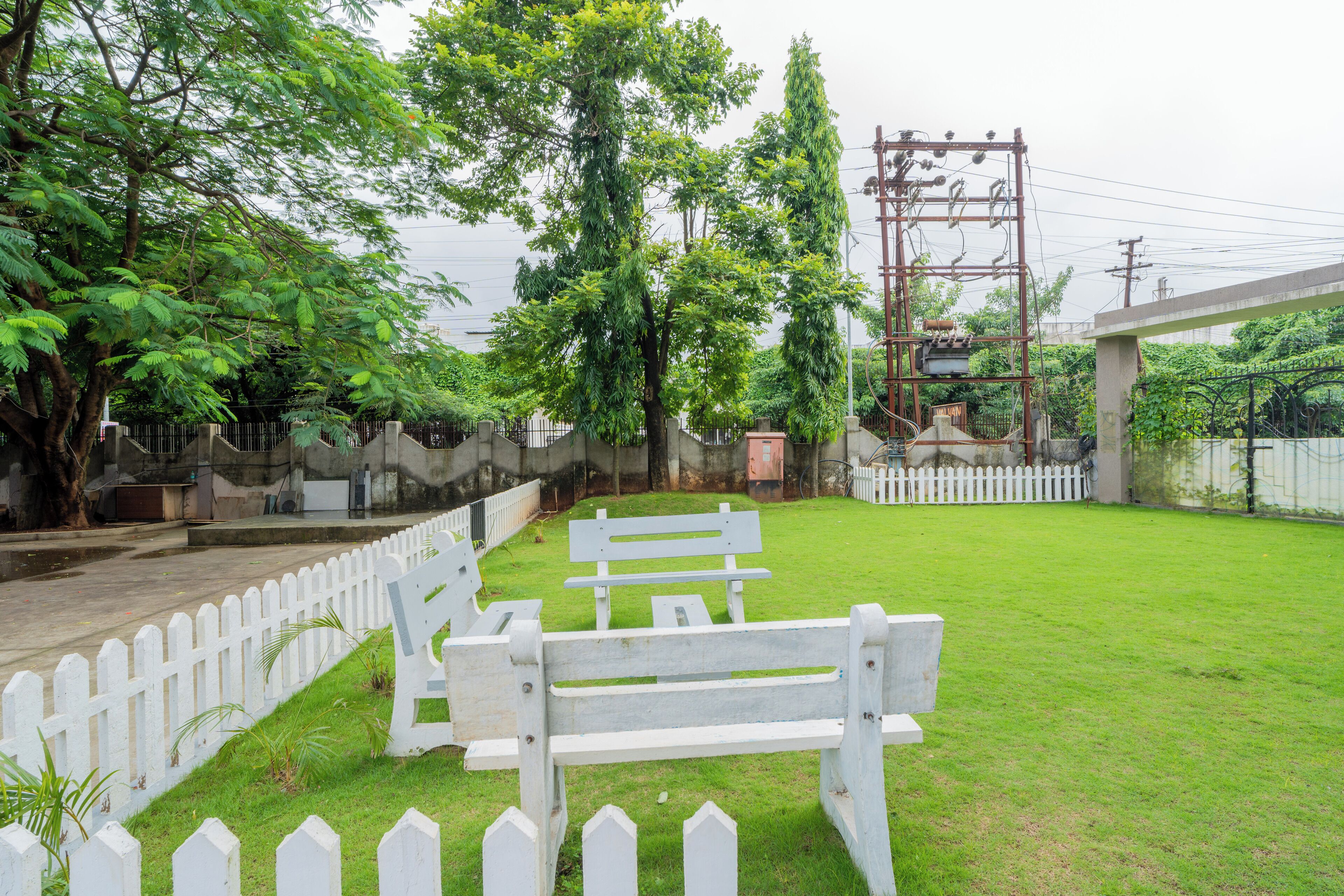 A grassy area with white picket fences and benches.